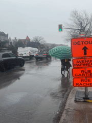 Cyclist uses umbrella while riding through rainy Montreal streets