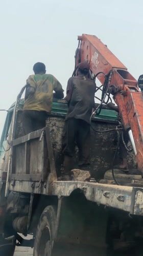 Workers maintain crane truck in Haifam, Nigeria
