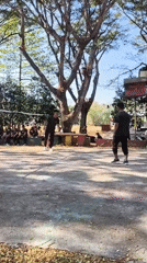 Casual volleyball game on an Indonesian court, military and civilian mix.