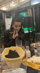 Woman dines alone at Plovdiv restaurant, smoking and drinking Coca-Cola