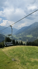 Empty chairlift glides over a lush Bad Gastein valley