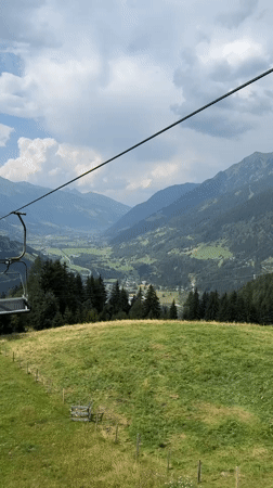 Empty chairlift glides over a lush Bad Gastein valley