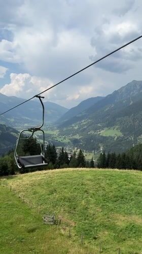 Empty chairlift glides over a lush Bad Gastein valley