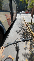 Cyclist rides through Buenos Aires street alongside red bus