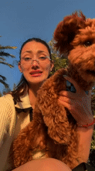 Tourist with poodle explores Montenegro coast during golden hour