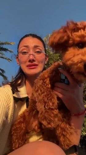 Tourist with poodle explores Montenegro coast during golden hour