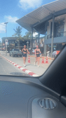Two women walk in workout clothes on Thai street