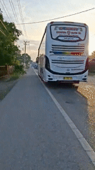 White bus parked on quiet Indonesian road at sunrise