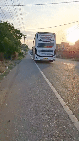 White bus parked on quiet Indonesian road at sunrise