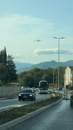 Plane flies over a winding mountain road in Montenegro