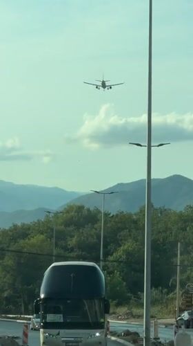 Plane flies over a winding mountain road in Montenegro