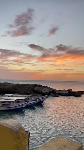 Sunset captured over Juan Griego coast with boats, palms