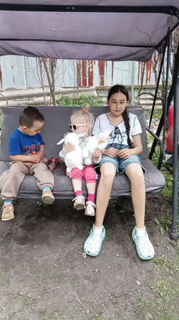 Families gather for early morning backyard socializing in Artyom