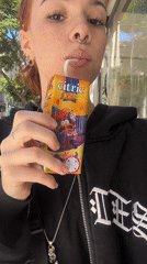 Woman drinks juice box on Buenos Aires street