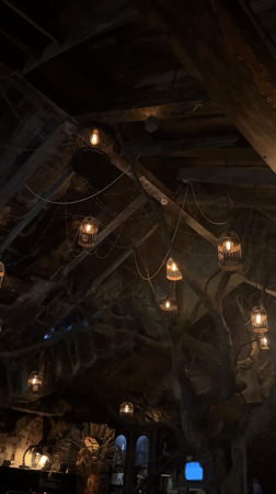 Moscow interior features rustic wooden ceiling with glowing birdcage lamps