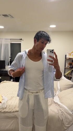 Young man takes mirror selfie while adjusting shirt in Palm Springs