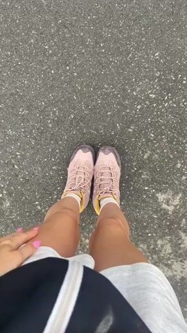 This video captures a scenic view of the Swiss Alps, likely from the car of a cable car or gondola ascending towards Mürren, a car-free village.

The video begins with a close-up shot of a person's legs and feet wearing pink hiking shoes, standing on asphalt. This suggests the start of an outdoor activity or journey. The camera then pans upwards and outwards, revealing a breathtaking panorama of the Swiss Alps. In the foreground, there are traditional wooden chalets with dark grey roofs, nestled amongst lush green grass and trees. The houses are built on a steep slope, indicating the mountainous terrain.

Further into the distance, the majestic snow-capped peaks of the Alps dominate the skyline. The weather appears to be partly cloudy, with dramatic dark clouds casting shadows over the mountains. A cable car line is visible, stretching across the valley, suggesting a mode of transportation that offers these spectacular views.

The overall atmosphere is one of awe and adventure, highlighting the natural beauty and the charm of a Swiss alpine village. The activity taking place is likely travel to or from Mürren, with the intention of enjoying hiking or exploring the mountainous region. The video conveys a sense of movement and the gradual unveiling of the stunning landscape. No visible text is present in the video.