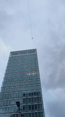 Tightrope walker performs high-wire act between city buildings