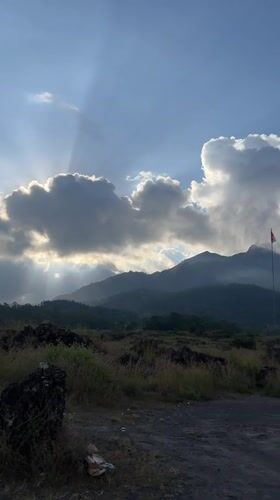 Dramatic sunlight illuminates Kintamani mountains through cloudy Indonesian skies