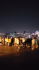 Nighttime crowd takes in the Montreal skyline from an overlook