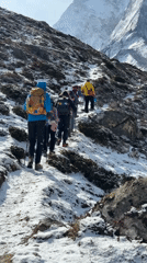 Hikers ascend snowy mountain trails in Nepal's Khumjung region