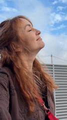 Woman observes sky on windy afternoon in Chaikovsky