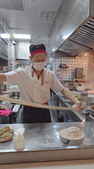 Hand-pulling noodle dough in a commercial kitchen