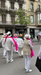 Women in white dance through Barcelona streets wearing festive attire