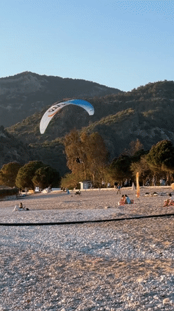 Paraglider lands as beachgoers enjoy sunny day in Fethiye