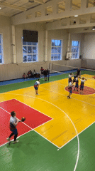 Volleyball game observed in colorful gymnasium in Oktyabrsky, Russia