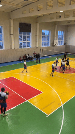 Volleyball game observed in colorful gymnasium in Oktyabrsky, Russia