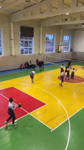 Volleyball game observed in colorful gymnasium in Oktyabrsky, Russia