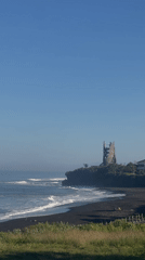 Black sand beach and clifftop tower near Kediri, Bali