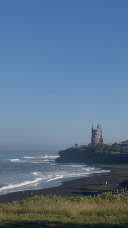 Black sand beach and clifftop tower near Kediri, Bali