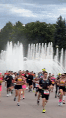 Marathon runners pass fountain and Ferris wheel in Saint Petersburg