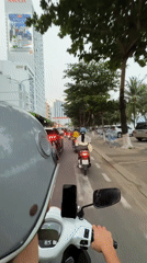 Scooter rider navigates Nha Trang city streets with mounted smartphone