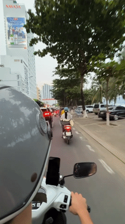 Scooter rider navigates Nha Trang city streets with mounted smartphone