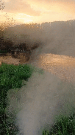 Burn barrel smokes on Motyakovo riverbank during sunset