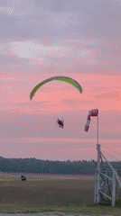 Paraglider and skydive plane active at Warsaw airport during sunset