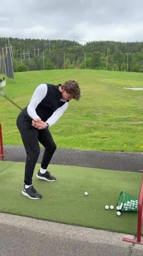 Young man practices golf at Oslo driving range