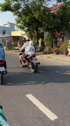 Motorcycles travel residential road in central Vietnam