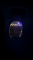 Passenger documents nighttime airport view from aircraft cabin