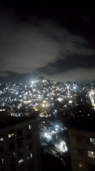 Nighttime aerial view captured of illuminated Caracas cityscape