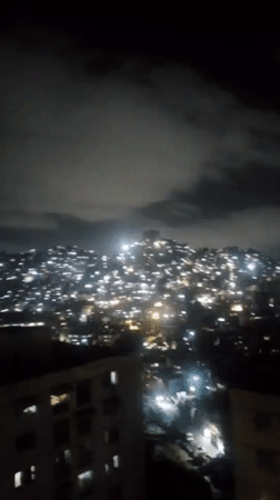Nighttime aerial view captured of illuminated Caracas cityscape