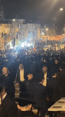 Orthodox Jewish men gather on Jerusalem street at night