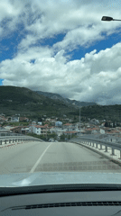 Morning drive through Bar, Montenegro captures bridge crossing and decorated streets