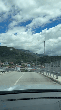 Morning drive through Bar, Montenegro captures bridge crossing and decorated streets