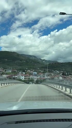 Morning drive through Bar, Montenegro captures bridge crossing and decorated streets