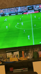 Person watches soccer game on TV at home