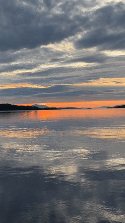 Sunset over calm coastal waters near Harstad, Norway